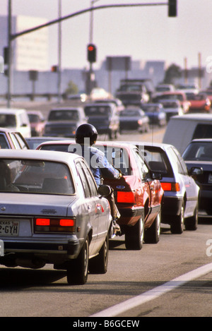 Motorrad fährt zwischen den Autos auf der Autobahn. Stockfoto