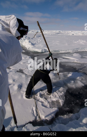 Inupiaq Walfänger öffnen ein Loch in das Packeis für potentielle Tierwelt Tschuktschensee passieren Stockfoto