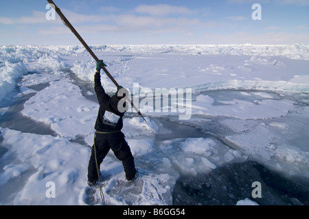 Inupiaq Walfänger öffnen ein Loch in das Packeis für potentielle Tierwelt Tschuktschensee passieren Stockfoto