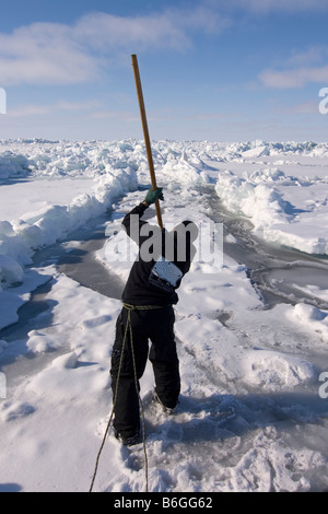 Inupiaq Walfänger öffnet ein Loch in das Packeis für potentielle Tierwelt Tschuktschensee passieren Stockfoto