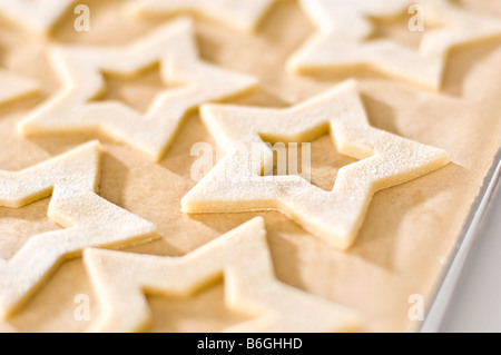 Sternförmige Ingwer Kekse gelegt auf Fett-Proof Papier vor dem Kochen. Dann verpackt in kleine Kisten für Weihnachtsgeschenke. Stockfoto