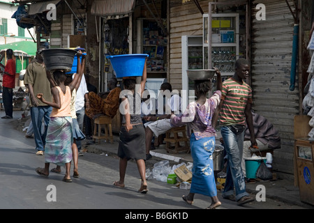 Junge Frauen-Markt Träger mit Gütern in Schüsseln auf dem Kopf Sandaga Market Dakar-Senegal Stockfoto