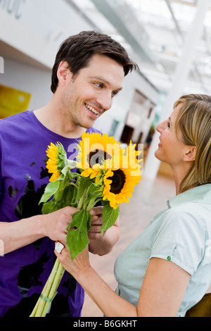 Mann zu einer Frau Blumen schenken Stockfoto