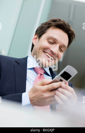 Mann lächelnd Holding-Handy Stockfoto