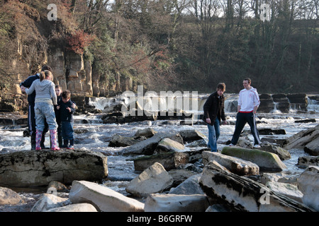 Jugendliche und Kleinkinder spielen auf den Felsen von Richmond fällt auf dem Fluß Swale Richmond North Yorkshire England Stockfoto