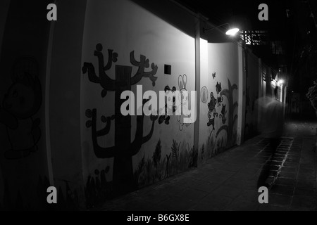 Abbildung Bewegung alte düster beleuchteten Gasse vorbei an weiß bemalten Wand im Schatten der obenliegenden Straßenlaternen in Kinn hinunter Stockfoto