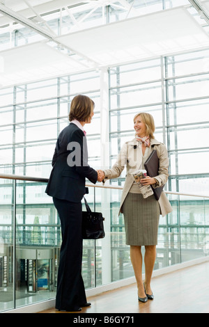 Zwei Frauen, die Hände schütteln Stockfoto
