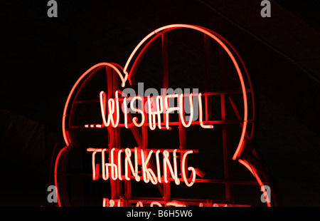 Ein "Wunschdenken" Zeichen im roten Neon in der Nacht. Stockfoto