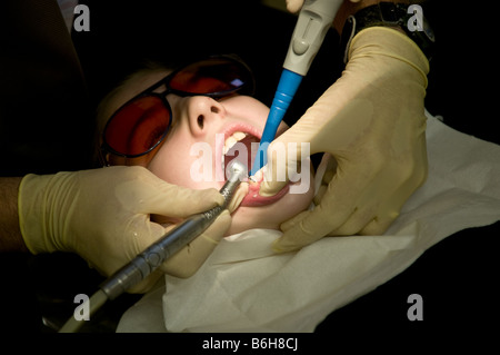 Vierzehn Jahre alten Mädchen, das ihre Zähne geprüft und gereinigt durch einen nationalen Gesundheitsdienst Kieferorthopäden Wales UK Stockfoto