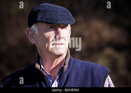 Senior woman in flache Kappe suchen nachdenklich außerhalb Stockfoto