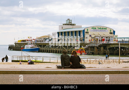 Junges Paar sitzt direkt am Meer in der Nähe von Bournemouth Pier, Dorset. UK Stockfoto