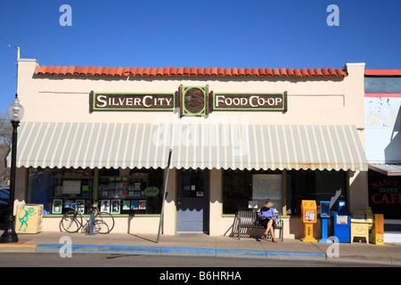 Person sitzt auf einer Bank vor einem malerischen Koop-Naturkost speichern Innenstadt von Bullard St Silver City, New Mexico, Vereinigte Staaten Stockfoto