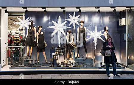 Frau mit Handy stehen vor Schaufenster mit Weihnachtsschmuck Cardiff Wales UK Stockfoto