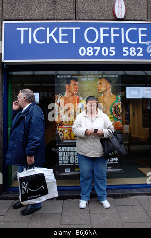 EIN KÄUFER WARTET AUF EINEN BUS VOR DEM PLAKAT FÜR DEN KAMPF ZWISCHEN JOE CALZAGHE UND MIKEL KESSLER BEI CARDIFF S MILLENNIUM STAD Stockfoto