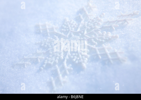 Schneeflocke Ornament Verlegung in frischen weißen Winterschnee Stockfoto