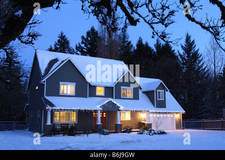 Winter-Haus in der Nacht mit Lichtern auf und Schnee Stockfoto