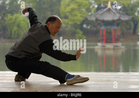 Chinesischer Mann tun Tai Chi Übungen im Black Dragon Pool mit 1-Cent-Pavillon auf der Rückseite. Lijiang, Provinz Yunnan, CHINA Stockfoto