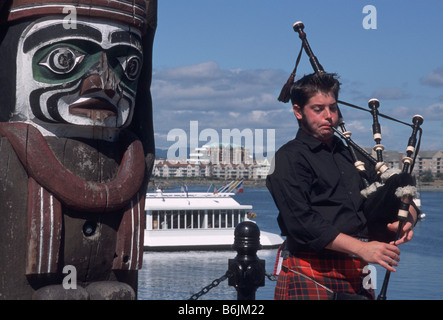 Kanada, British Columbia, Victoria Totempfahl und Dudelsackpfeifer, der Inner Harbor Stockfoto