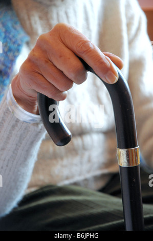 Eine ältere Frau Hand hält ihren Gehstock. Stockfoto