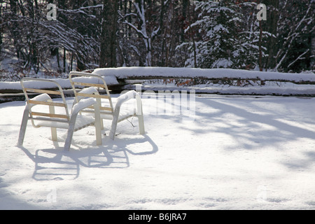 Sommer-Lounge-Sessel Links auf Schnee, jetzt dramatisch in die langen Schatten der späten Nachmittag & Winter Schneedecke im Dezember warten Stockfoto