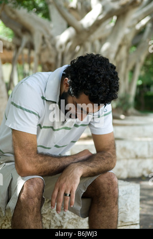 Trauriger Mann sitzen im park Stockfoto