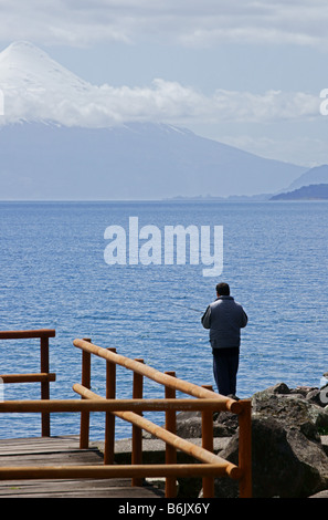 Fischer am Felsen mit Vulkan Osorno im Hintergrund, Puerto Varas Stockfoto