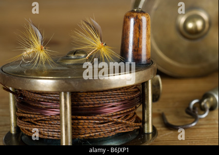 England.  Trockenfliegen auf einer traditionellen Messing-Fliegenfischen-Spule. Stockfoto