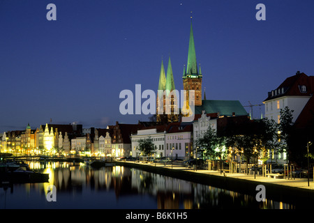 Die Kirchen St. Petri und St. Mary überragt historischen Häusern am Rande des Flusses Trave in Lübeck Stockfoto