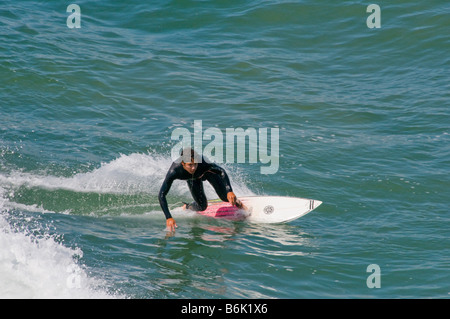 Junge männliche Teenager Surfer fangen eine Welle Stockfoto