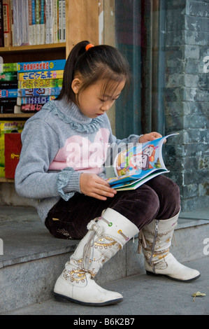 Mädchen lesen ein Buch vor einer Buchhandlung Peking China Stockfoto