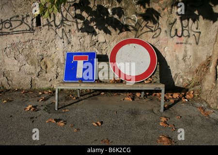 zwei beschädigte Verkehrszeichen auf Bank im park Stockfoto