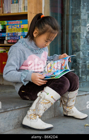 Mädchen lesen ein Buch vor einer Buchhandlung Peking China Stockfoto