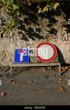 zwei beschädigte Verkehrszeichen auf Bank im park Stockfoto