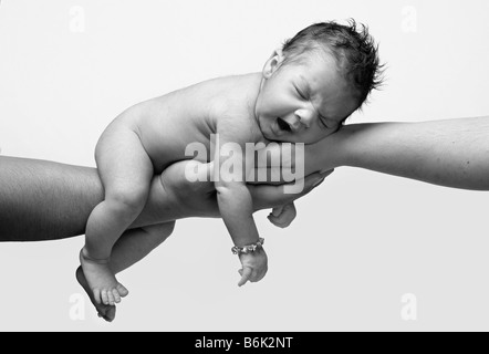 neugeborenes Baby in schwarz / weiß Gähnen und von beiden Eltern Händen gehalten Stockfoto