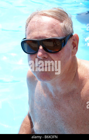 Mann im Schwimmbad mit Sonnenbrille Stockfoto