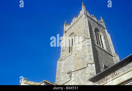 Norfolk Flintstein Feuerstein englischen senkrecht gotischen Kirchturm in warmes Licht mit blauem Himmel Stockfoto