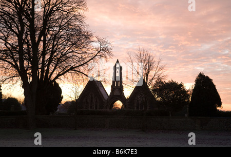 Roter Himmel am Morgen und den Sonnenaufgang über der Kapelle, Newmarket Friedhof, Suffolk, UK Stockfoto
