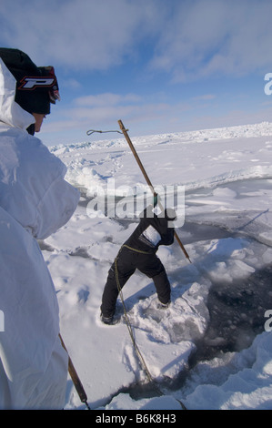 Inupiaq Subsistenz Jäger öffnet ein Loch in das Packeis für potentielle Tierwelt Tschuktschensee passieren Stockfoto