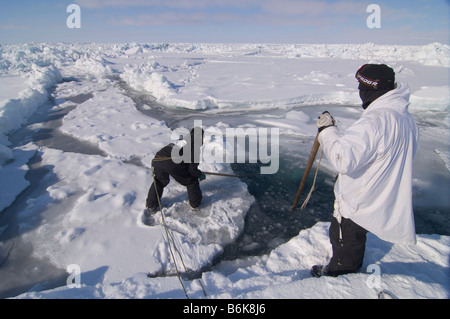 Inupiaq Subsistenz Jäger öffnet ein Loch in das Packeis für potentielle Tierwelt Tschuktschensee passieren Stockfoto
