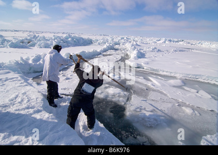 Inupiaq Subsistenz Jäger öffnet ein Loch in das Packeis für potentielle Tierwelt Tschuktschensee passieren Stockfoto