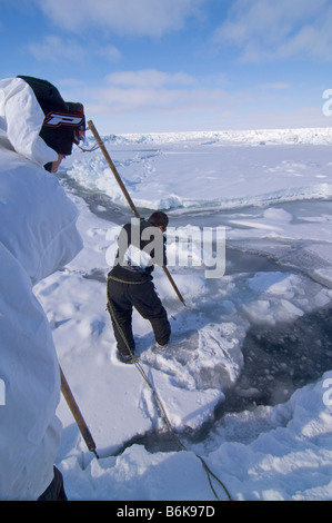 Inupiaq Subsistenz Jäger öffnet ein Loch in das Packeis für potentielle Tierwelt Tschuktschensee passieren Stockfoto