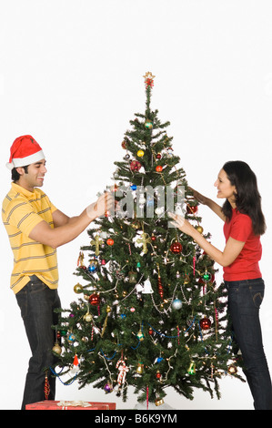 Paar einen Weihnachtsbaum zu schmücken und lächelnd Stockfoto