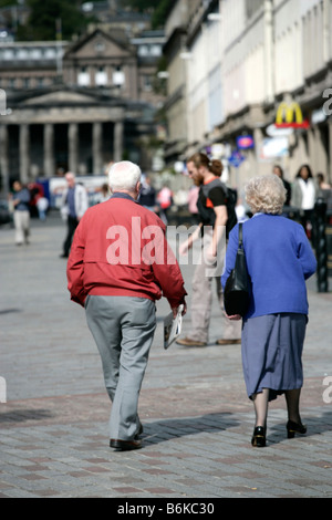 Stadt von Dundee, Schottland. Rentner-paar zu Fuß in Dundee City Zentrum mit Dundee High School im Hintergrund. Stockfoto