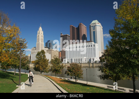 Columbus Downtown auf der Suche nach Nordosten über den Scioto River Columbus Ohio Mann auf dem Fahrrad hat Kuba auf Hemd Stockfoto