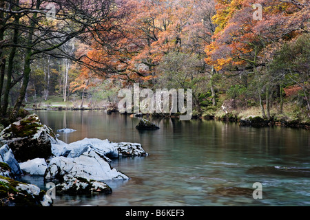 Das Derwent River fließt durch das herbstliche Farbenspiel von Borrowdale, Cumbria Stockfoto