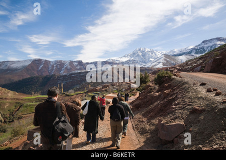 Marokko Touristen zu Fuß auf Country Track zu traditionellen Berber Bergdorf Sidi Faress im Hohen Atlas im Winter Stockfoto