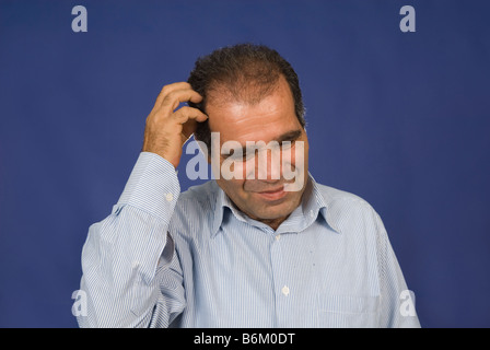 Mann kratzte sich am Kopf Stockfoto