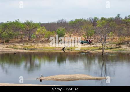 weiten Blick Landschaft SAFARI Pirschfahrt Jeep Fahrzeug Menschen in Südafrika rote Wüstenstaub Feldweg fahren weg Safari Savanne woodl Stockfoto