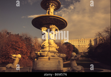 Fuente de las Conchas Brunnen in Campo de Moro Gärten im Herbst, Königspalast dahinter, Madrid, Spanien. Mit einem Wärmeschutzfilter aufgenommen Stockfoto