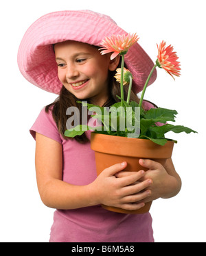 junges Mädchen mit einem rosa Hut und rosa Gänseblümchen in einem Blumentopf Stockfoto